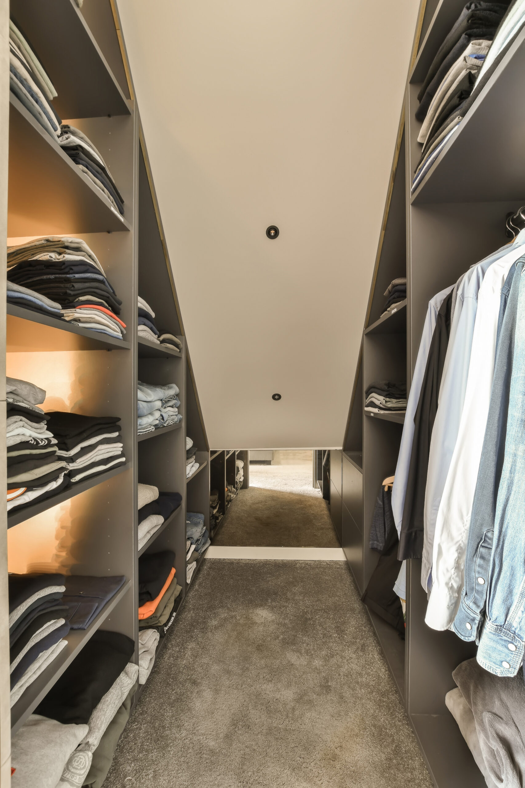 a walk - in closet with lots of clothes on the shelves and hanging hangers, all ready for use